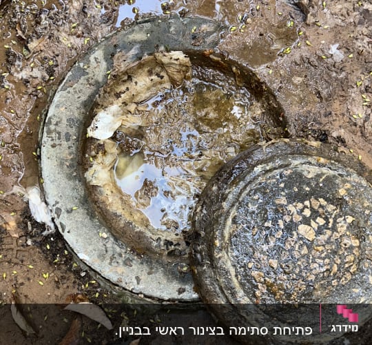 פתח ביוב פתוח עם מכסה מונח בצד